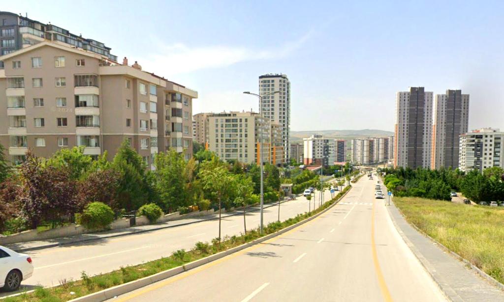 Yaşamkent bulvarında geniş yollar, apartman ve rezidanslarla çevrili yeşil alanlar